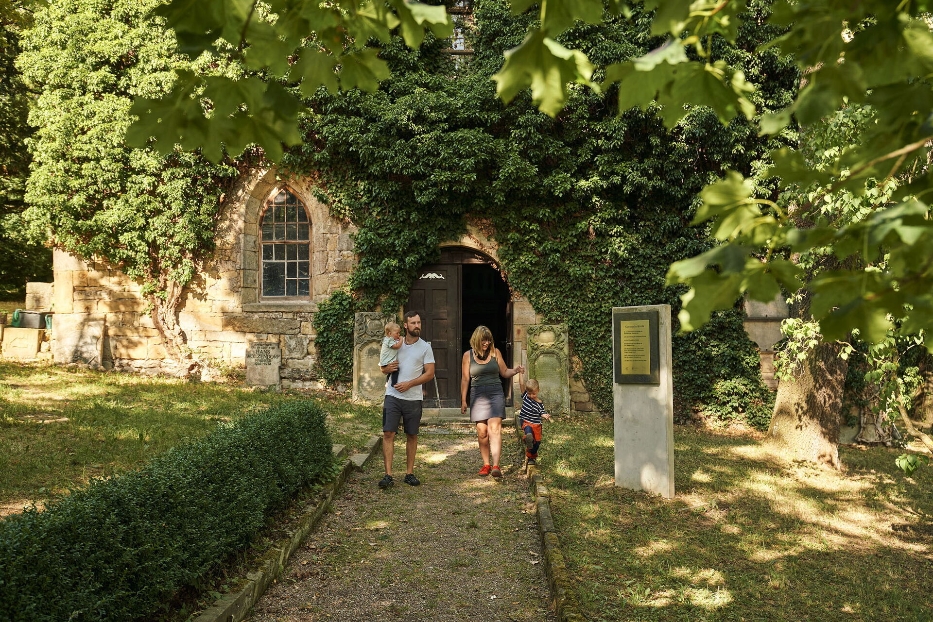 Eine Familie kommt aus der Gottesackerkirche in Creuzburg
